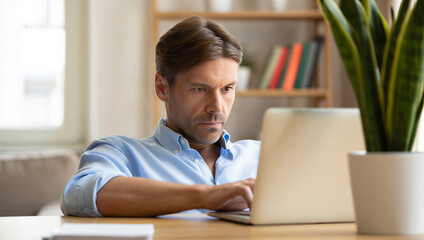 Professional man focused on laptop, working from home. Adult using computer for online business, remote education, or digital task.