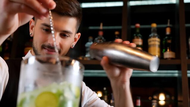 Male Bartender Mixing Cocktails in a Bar