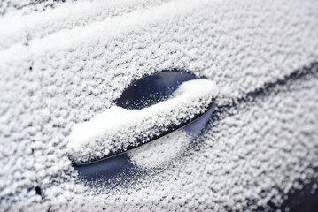 Winter snow covering car door handle. Frozen car. Car door handle buried under winter snow, winter...