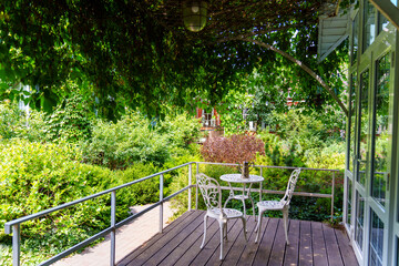 Outdoor seating area near greenery in sunny weather