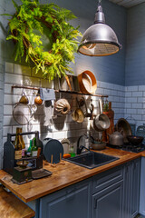 A kitchen features pots and utensils hanging on a wall