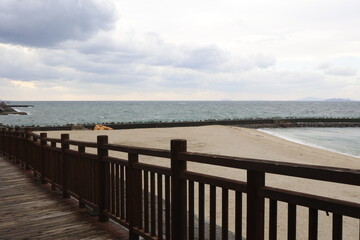 Obraz premium 冬の曇り空と荒れた瀬戸内海を木の柵越しに望む風景。愛媛県伊予市。