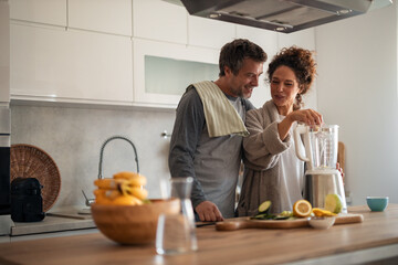 Healthy Warm Morning Couple In Modern Kitchen Preparing Fresh Smoothie Together With Blender And...