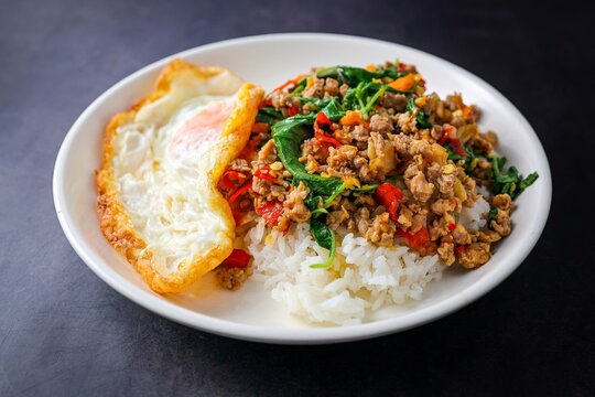 Homemade Rice topped with stir fried Thai basil with minced pork and fried egg, pad ka praow moo sap	
