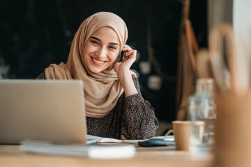 Young Arab woman conducts online math tutoring session while smiling at her laptop in a cozy study space during the day