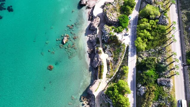 Aerial drone cinematic video of beautiful beach with wonderful seaside promenade of Kato Petres featuring Cave Archangel Michael Panormitis, Rhodes island, Dodecanese, Greece
