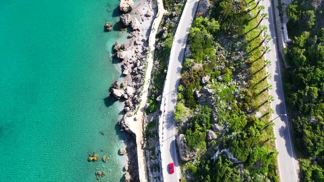 Aerial drone cinematic video of beautiful beach with wonderful seaside promenade of Kato Petres featuring Cave Archangel Michael Panormitis, Rhodes island, Dodecanese, Greece