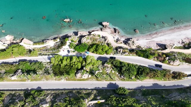 Aerial drone cinematic video of beautiful beach with wonderful seaside promenade of Kato Petres featuring Cave Archangel Michael Panormitis, Rhodes island, Dodecanese, Greece