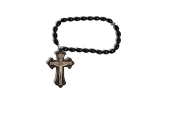 Black rosary beads with a silver crucifix showing Jesus Christ on a pure white background for religious or spiritual concepts.