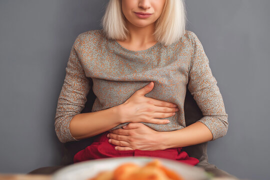 Blonde woman suffering from stomach pain after eating