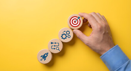 hand placing target goal block on yellow background