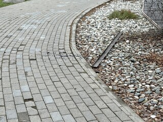 Worn Brick Pathway With Moss And Uneven Pavers, Narrow Urban Route With Weathered Grout And Small Cracks, Pedestrianfocused Composition Conveying Age And LowMaintenance Walkway Condition