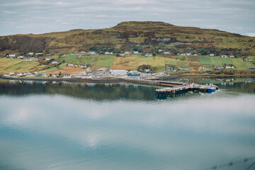 Obraz premium Landscape of a sweeping view of Uig Bay (Loch Snizort) and the picturesque village and ferry terminal below