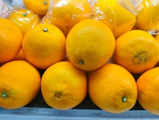 Close up photo of a pile of fresh oranges in a fruit shop