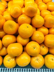 Fresh Orange Fruits Piled Up at Market Stall Background