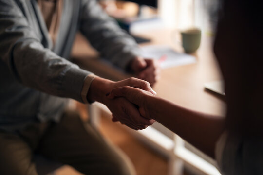 Handshake Between Two People In A Cozy Indoor Setting Signaling Trust And Connection