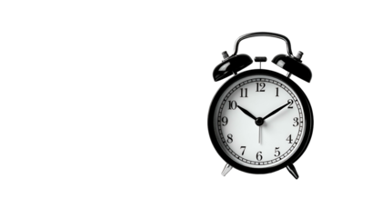A classic black analog alarm clock on a black background, slightly off-center and well-lit