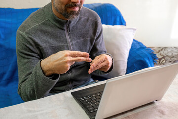 Man communicating through sign language during online video call
