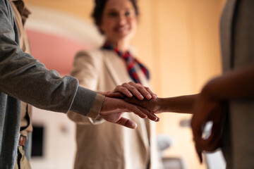 Obraz premium Warm Teamwork And Unity As Hands Stack Together In A Friendly Office Setting