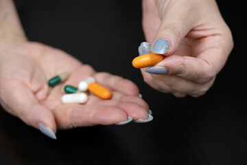 Pills in a hands of woman. Concept of antibiotics, vitamins, dietary supplements