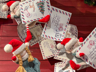 Paper Christmas garland inspired by vintage postcards and airmail envelopes, decorated with holiday tree, reindeer, and postage stamp illustrations, hanging as nostalgic festive decor indoors
