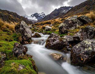 Mountain stream rushes below snow-capped peaks