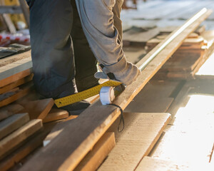 Construction worker with lumber, Woodworker marks wood.