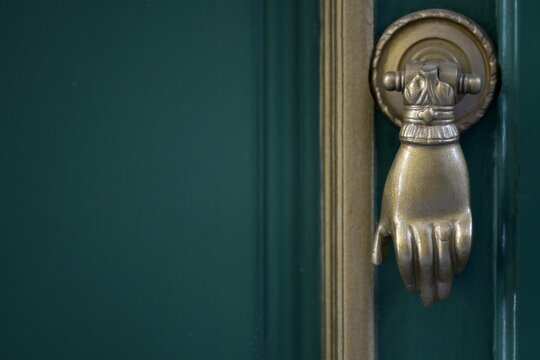 Old Neoclassical house cypress green wooden entrance door with an antique brass knocker in Nafplio, Greece