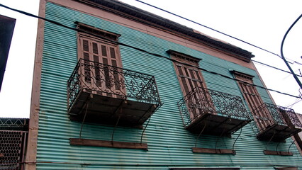 Building with green corrugated metal walls and small upstairs balconies in the La Boca neighborhood of Buenos Aires, Argentina