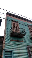 Building with green corrugated metal walls and a small upstairs balcony in the La Boca neighborhood of Buenos Aires, Argentina