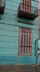 Building with green corrugated metal walls and a small upstairs balcony in the La Boca neighborhood of Buenos Aires, Argentina