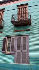 Building with green corrugated metal walls and a small upstairs balcony in the La Boca neighborhood of Buenos Aires, Argentina