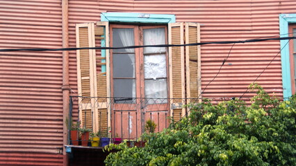 Damaged shutters over a door in a pink wall, in the La Boca neighborhood of Buenos Aires, Argentina