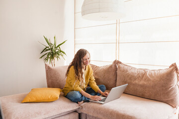 Cheerful woman using silver laptop