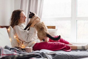 Cute cat on owners's hands at home