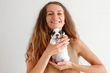 Attractive Woman holds tiny Puppy in her arms, little Dog with open mouth