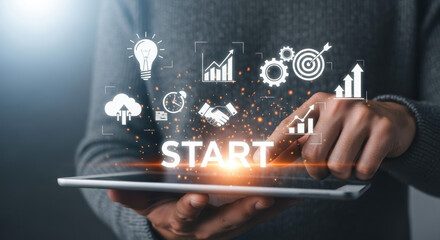 Close-up of a man using a tablet displaying "START" and various white icons. Concepts include business, strategy, technology, innovation and growth. Soft lighting. 