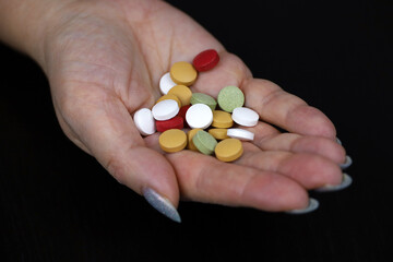 Pills in female palm of hand. Concept of antibiotics, vitamins, dietary supplements
