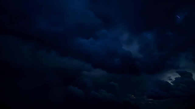 Dark storm clouds illuminated by lightning in night sky  