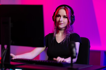Young female gamer streaming online in a vibrant gaming setup