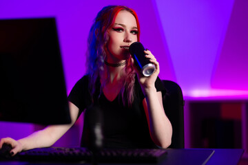 Young woman gaming in a colorful neon-lit studio environment