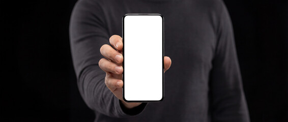 Hand holding smartphone displaying a white vertical placeholder, mockup screen with large white space for text or sensitive data, anonymous presentation on dark background, mobile technology concept