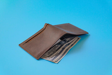 A brown leather wallet on color background.