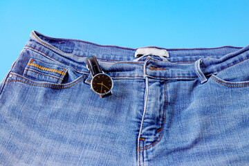 Black watch in blue jeans pocket.Fashion concept.