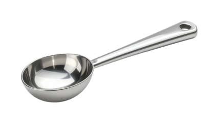 Close-up of a shiny, metallic serving spoon with a hole in the handle, isolated on black