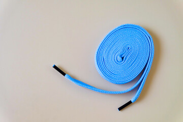 A blue sneakers shoelaces on color background, crumpled laces.