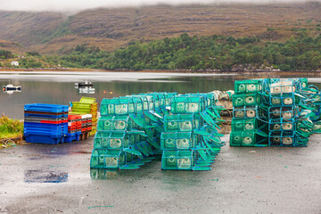 Crab and lobster pots stacked beside loch in rural Scotland