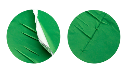 Two green circular stickers, one partially torn revealing white. Both have diagonal creases