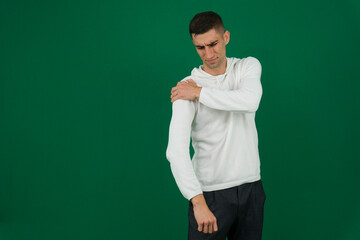 Close-up side view of a young businessman suffering from shoulder pain against white background. High quality photo
