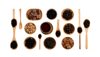 Overhead shot of tea ingredients tapioca pearls, sugar, tea leaves, and tea, in wooden bowls/spoons